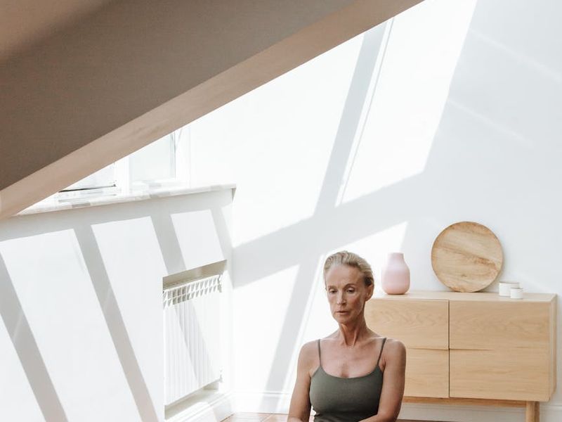 Person practicing yoga in a bright minimal room.